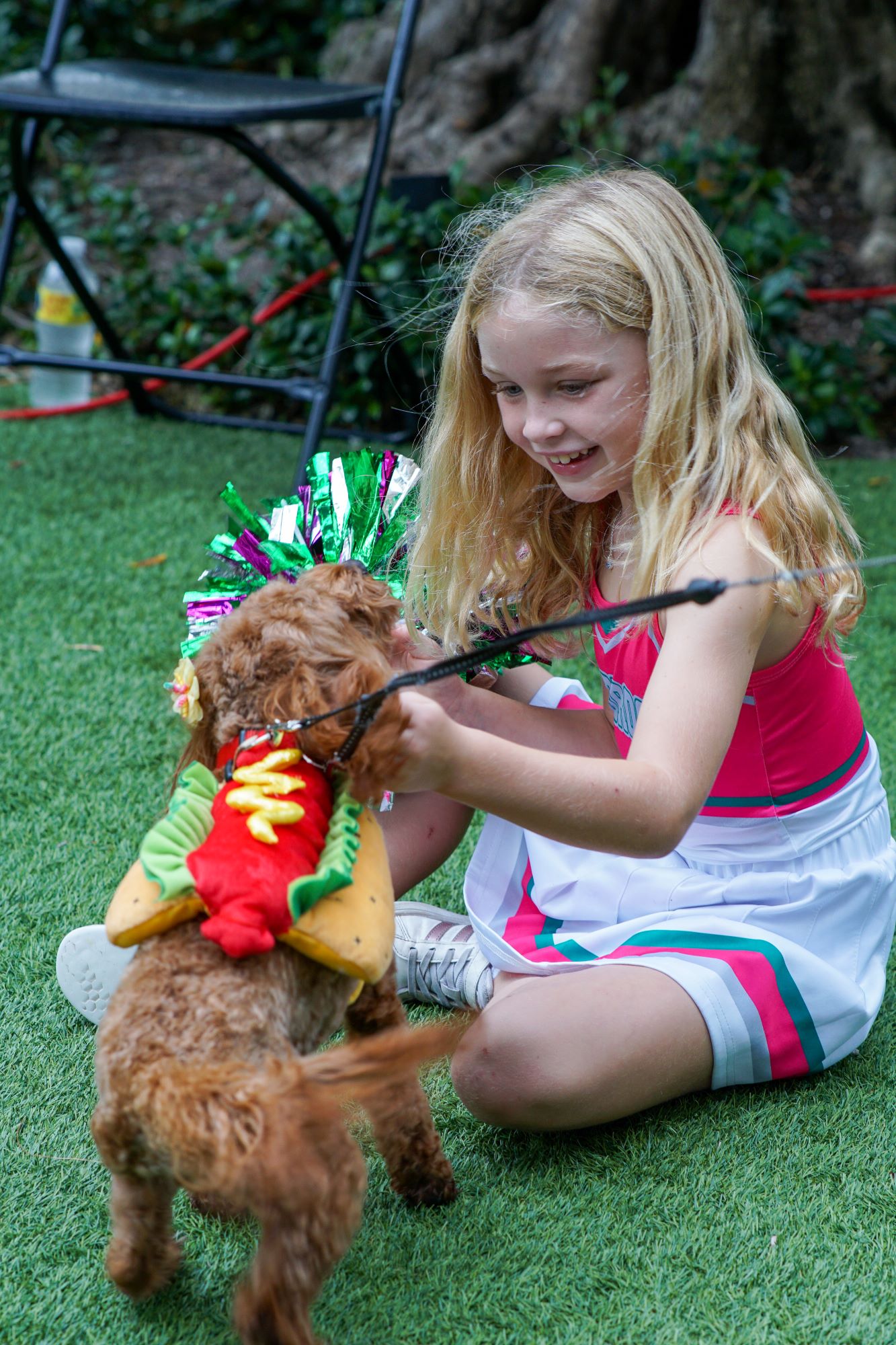 girl and pet sitting, dressed in costume on the lawn