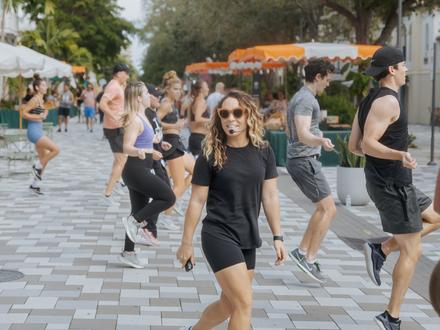 woman crossing the street in the middle of a workout class