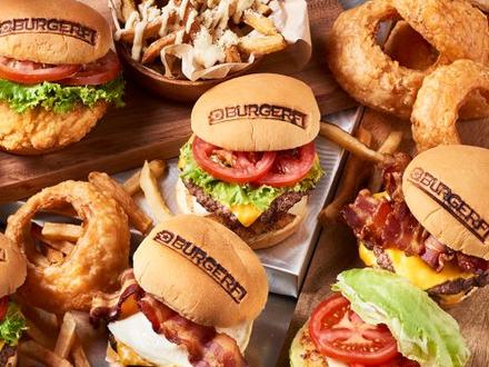 multiple burgers and sides on wooden and metal background