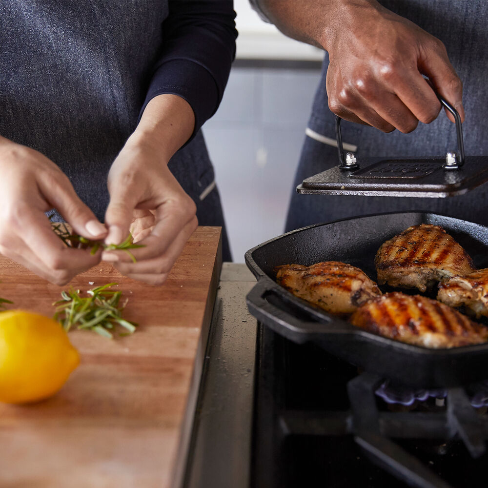 Couple cooking together with chicken and lemon
