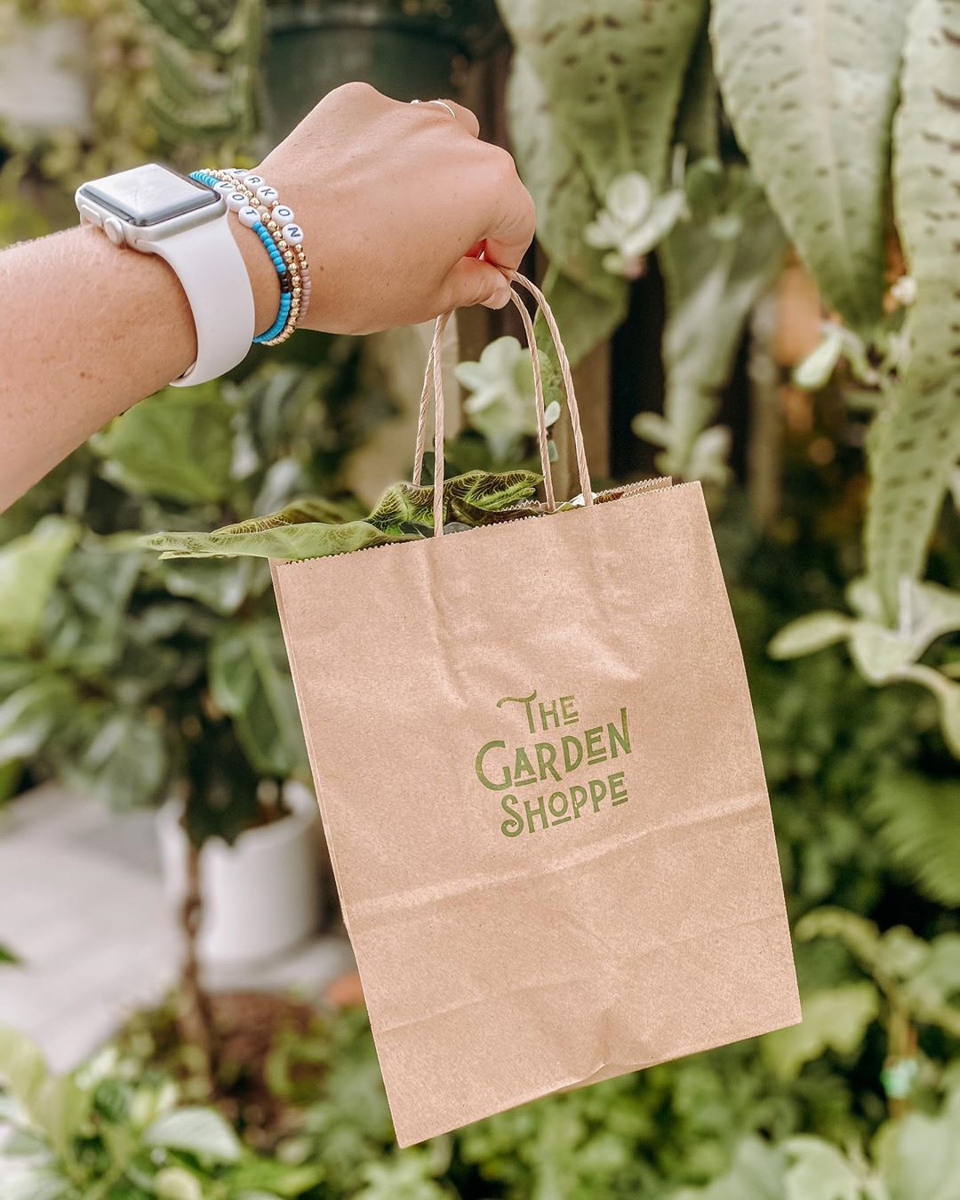 Girl holding garden shoppe bag up