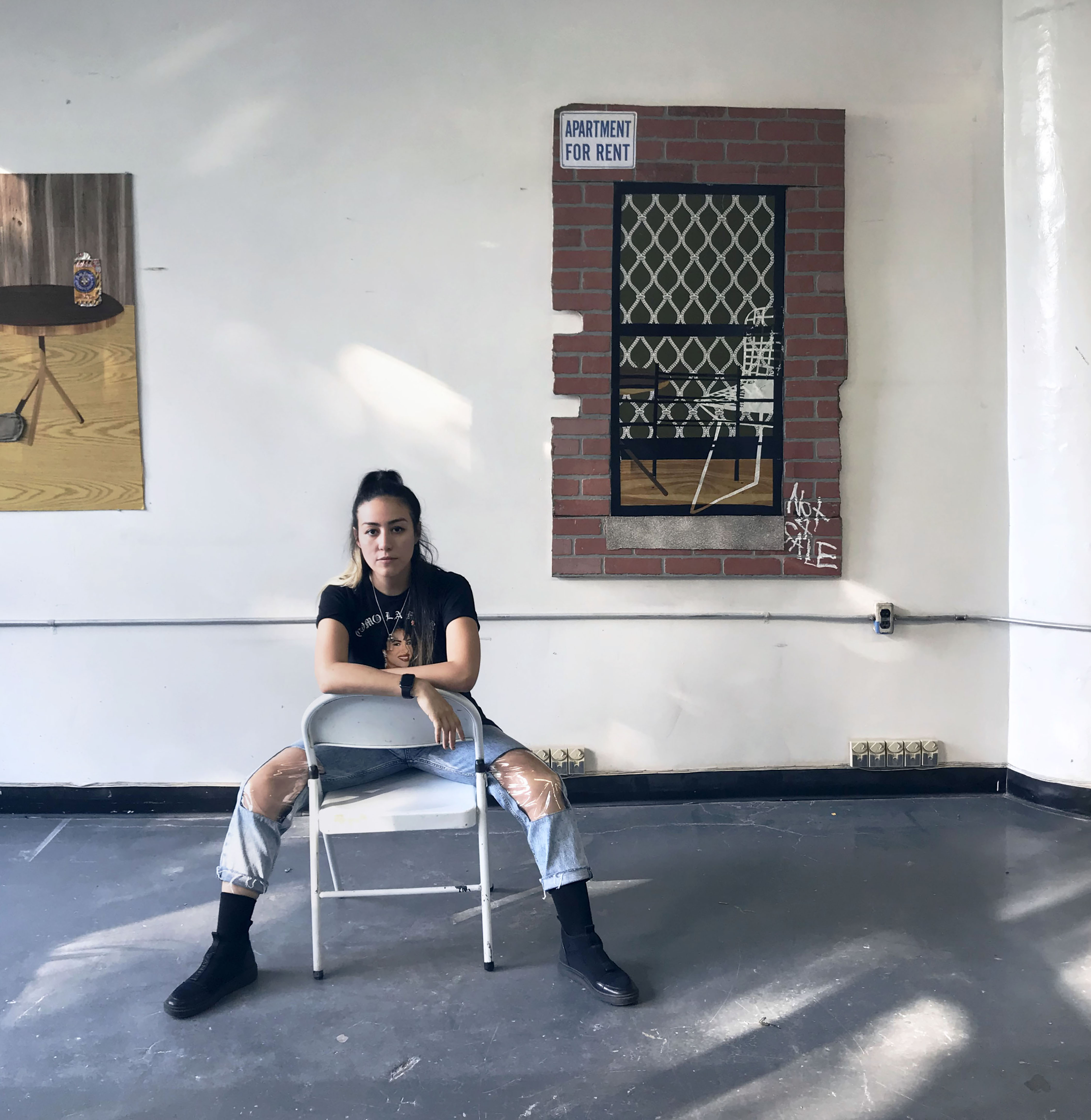 Artist sitting in chair in front of work
