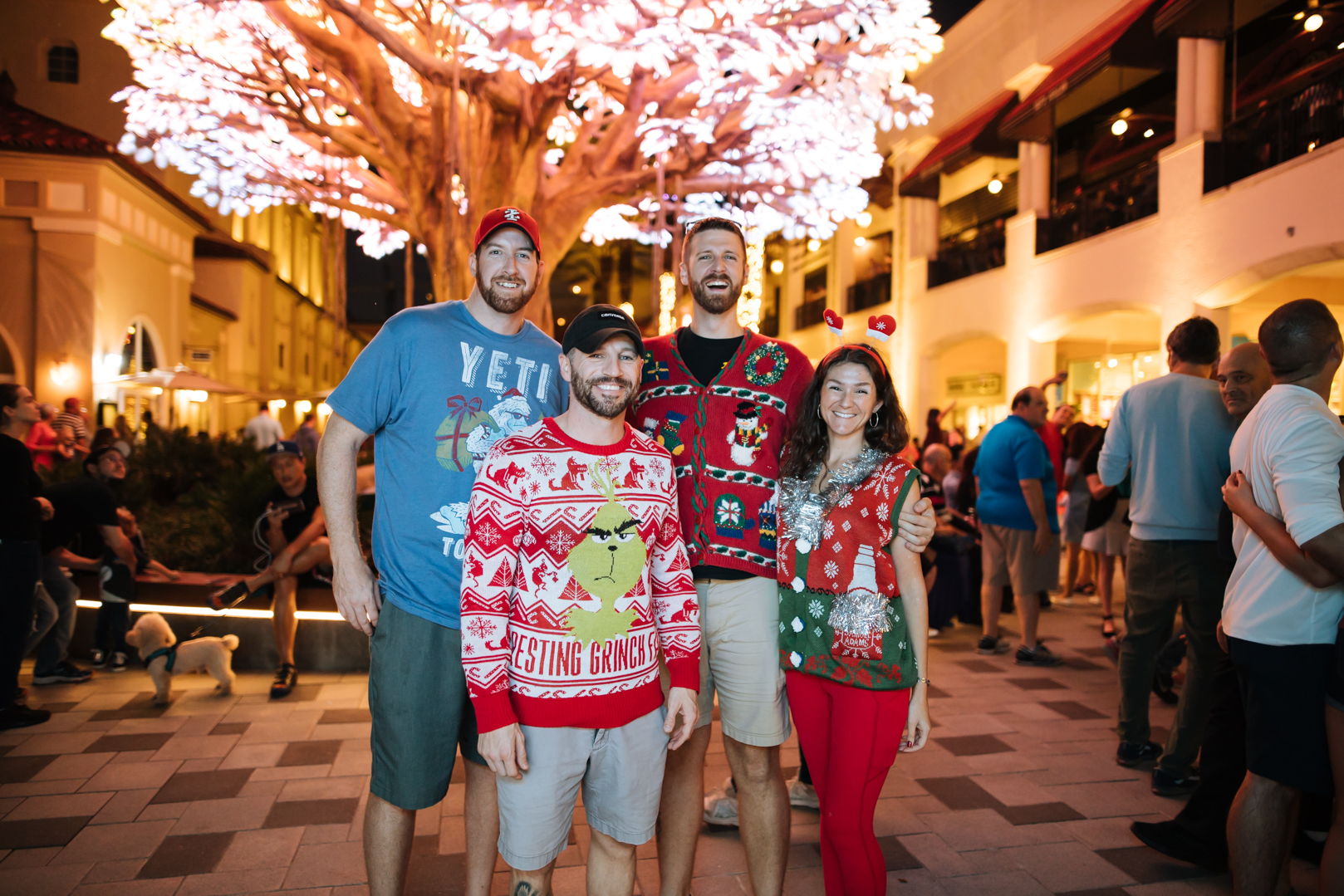 A group of people wearing holiday ugly sweaters