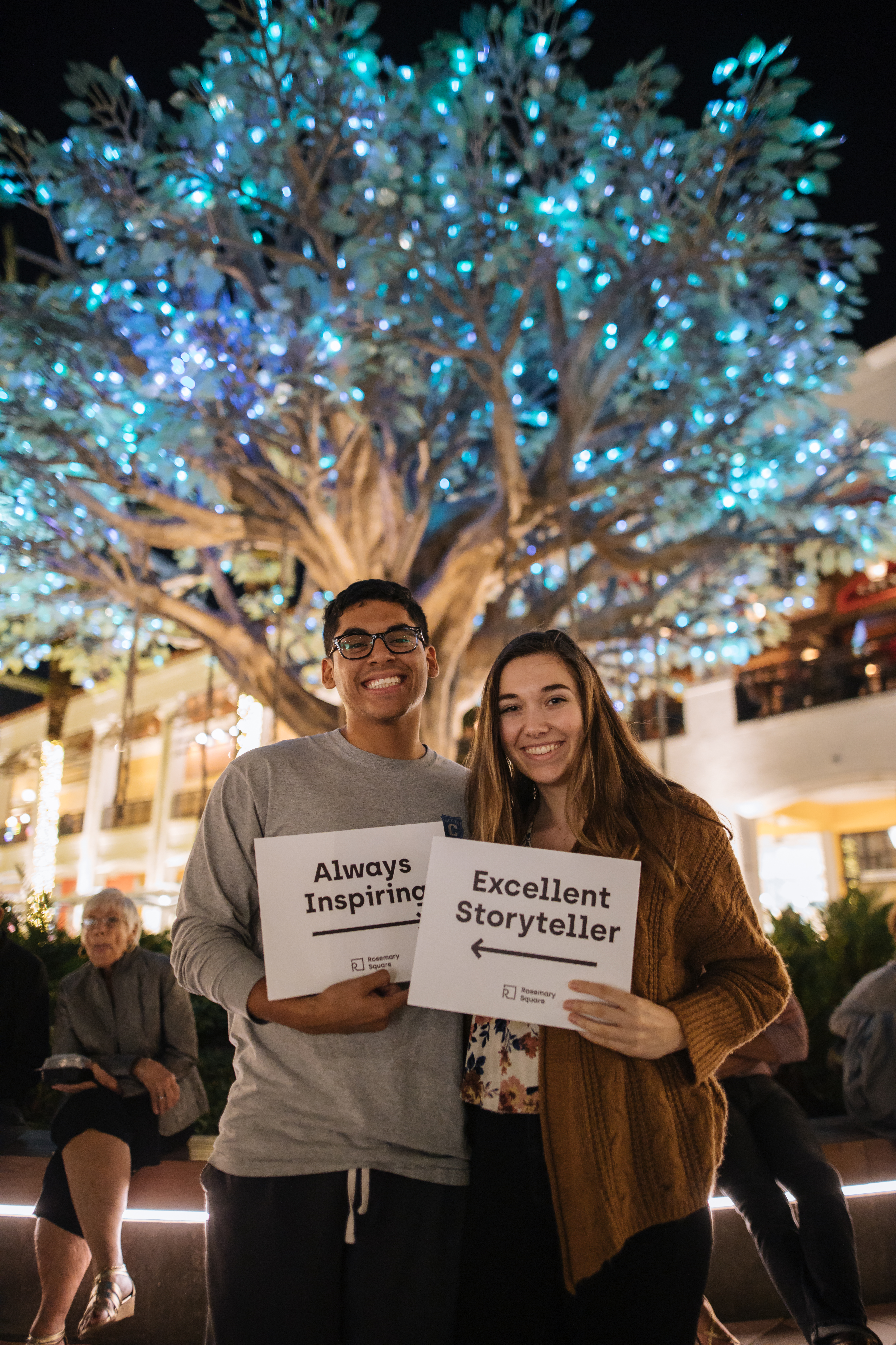 couple holding compliment signs 