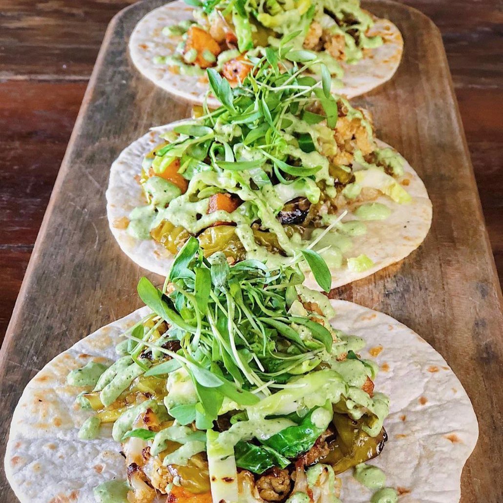 three tacos lined up on plate