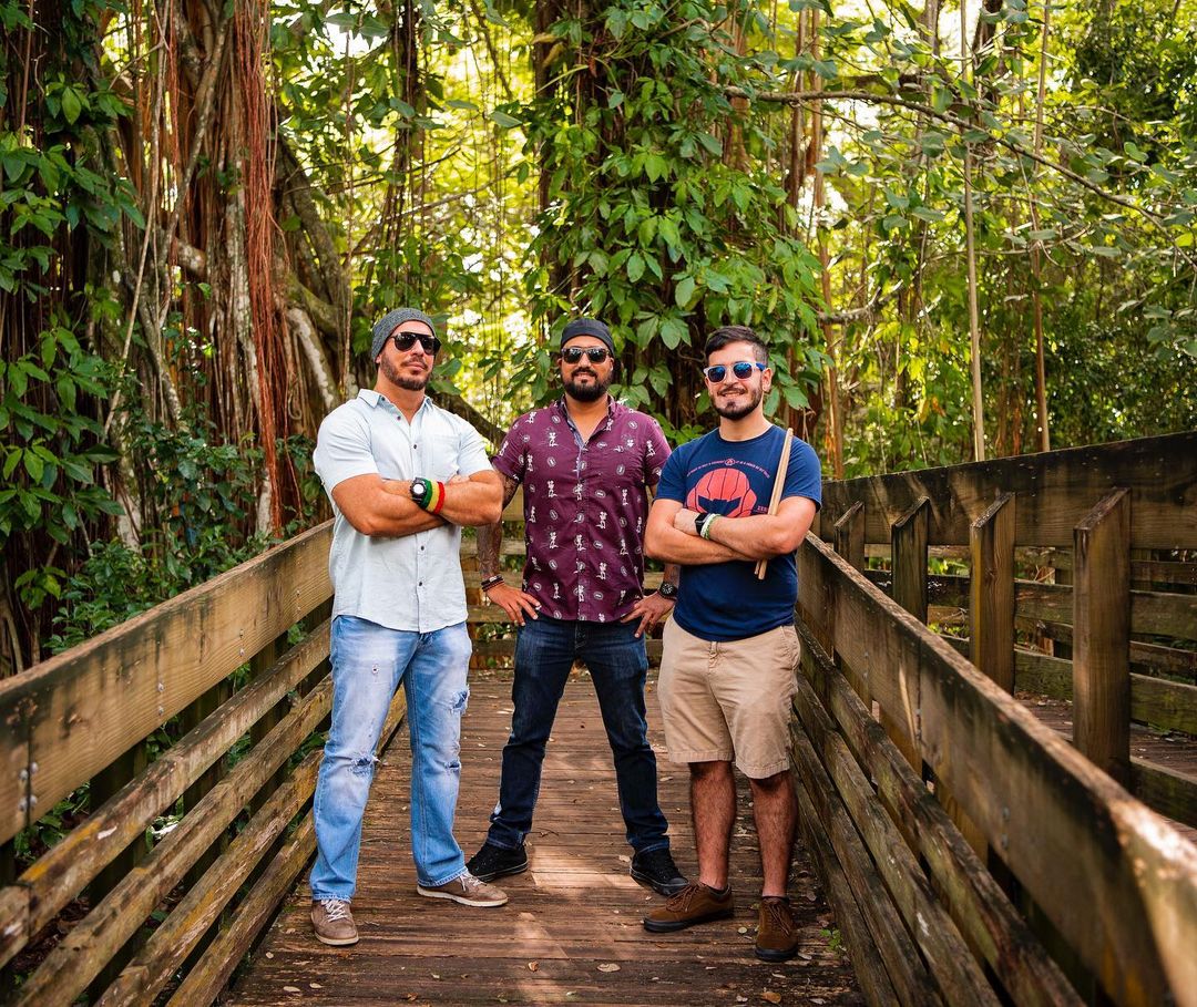three male musicians standing together outside