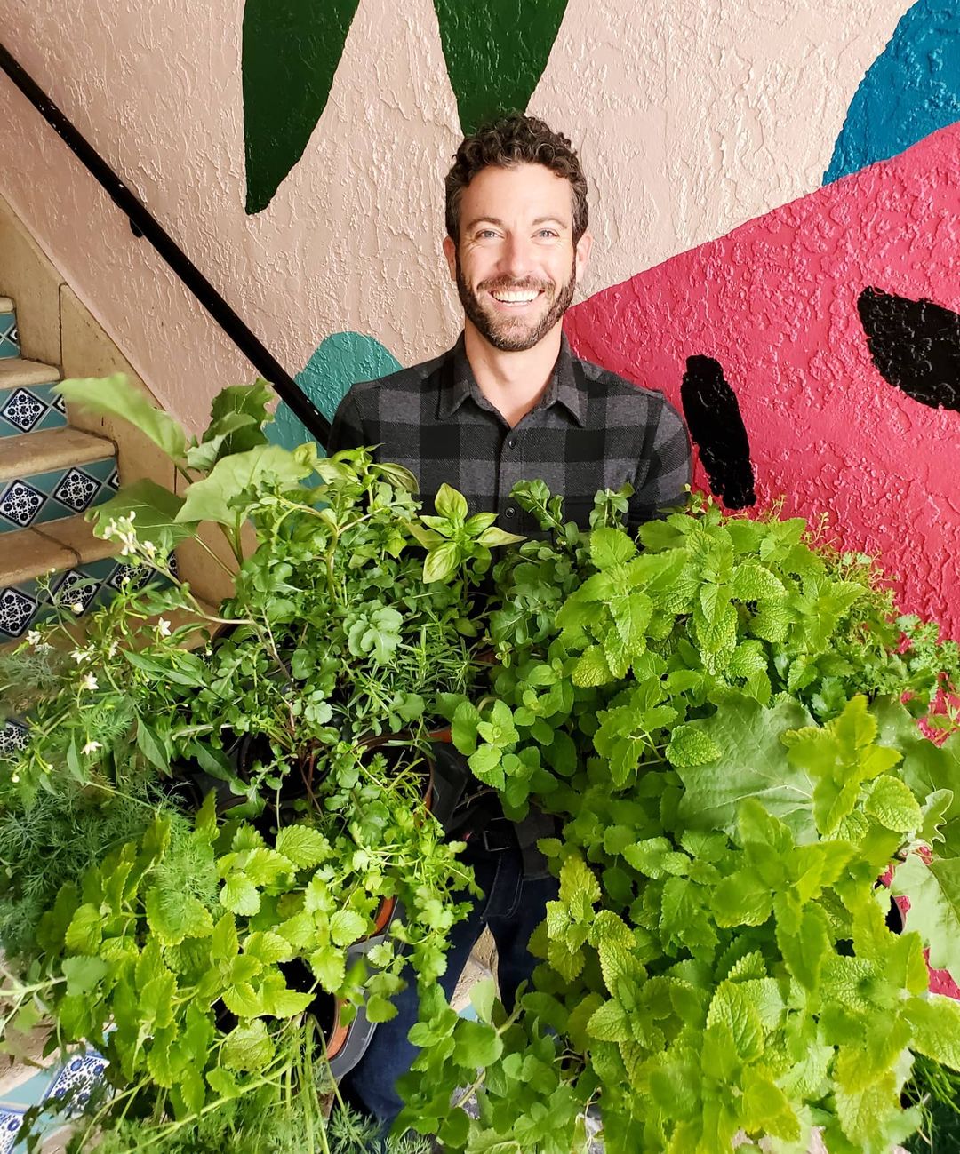 Man holding armful of vegetables plants 