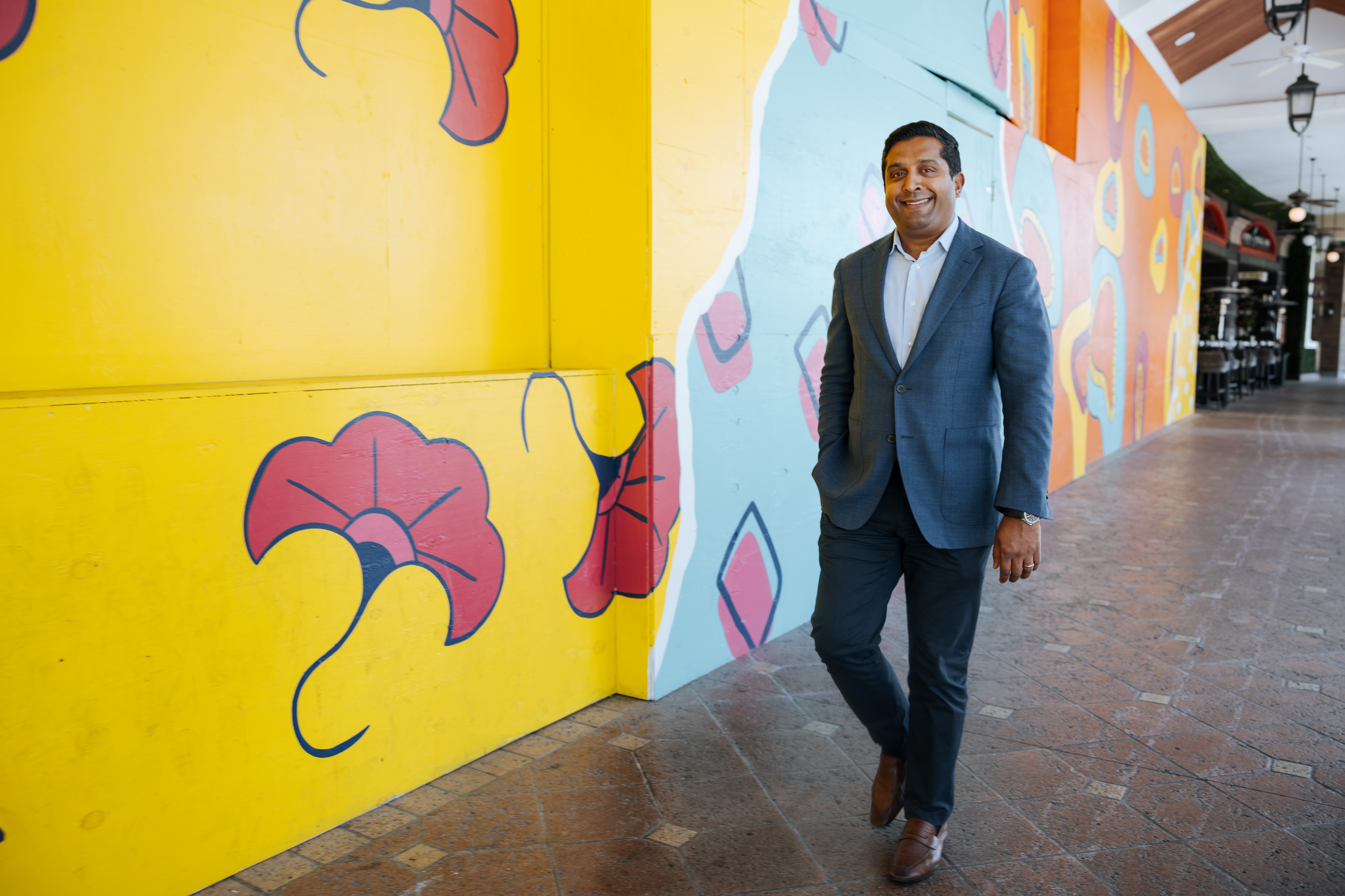Man walking past brightly painted mural