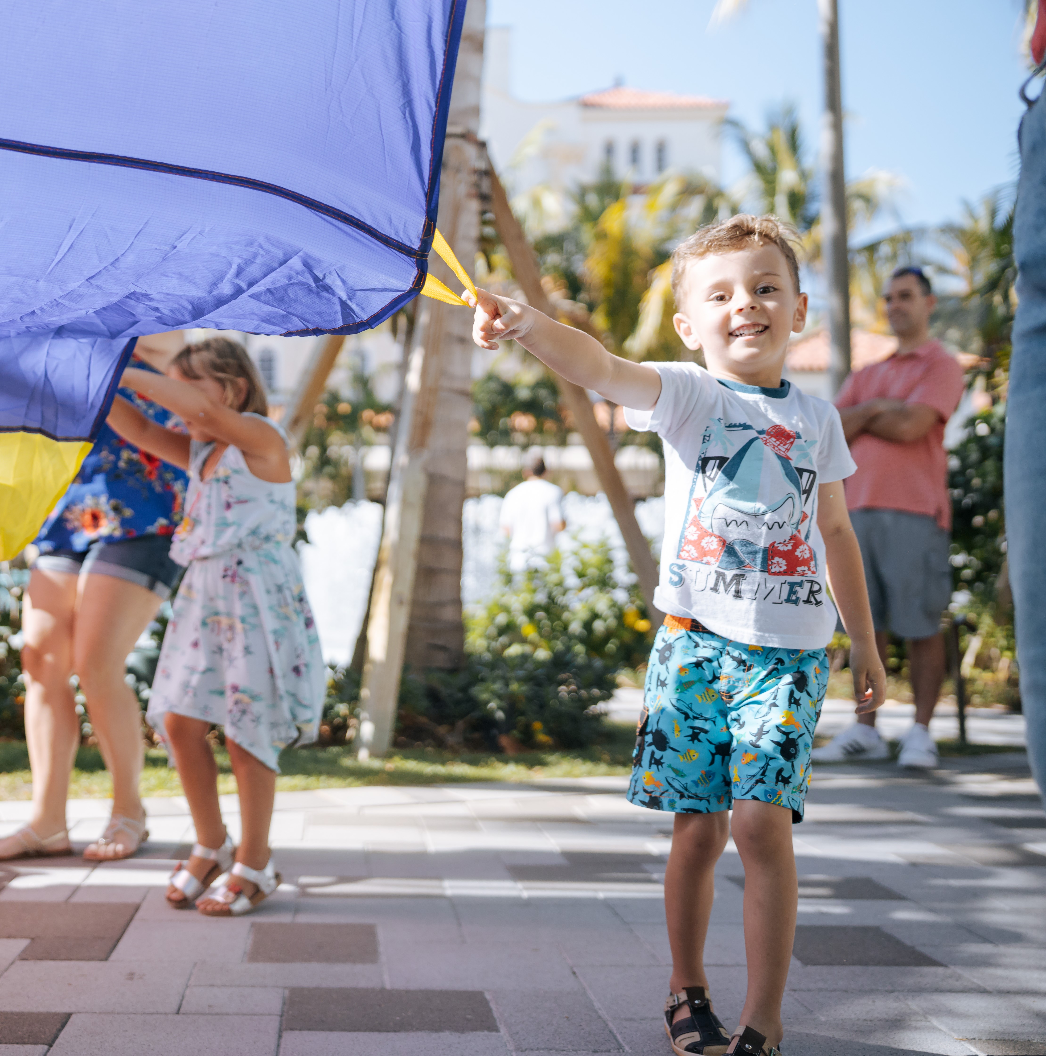 Young boy holding colorful parachute 