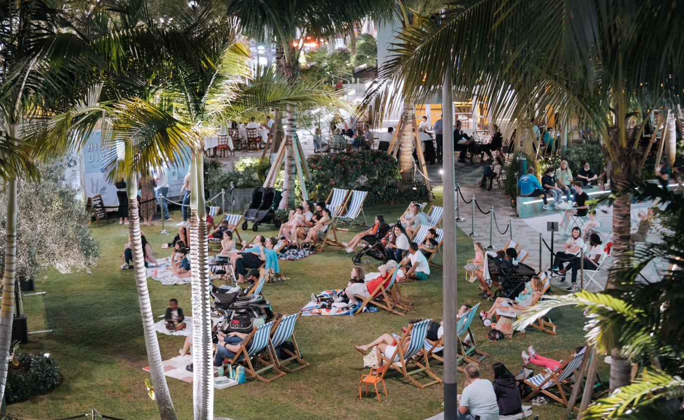 people sitting on lawn chairs watching outdoor movie