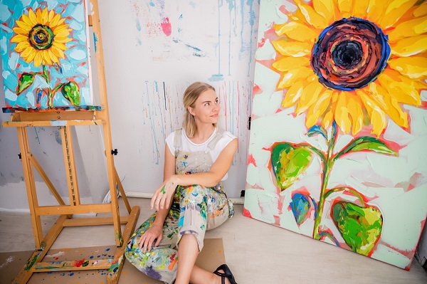 Painter sitting between two paintings