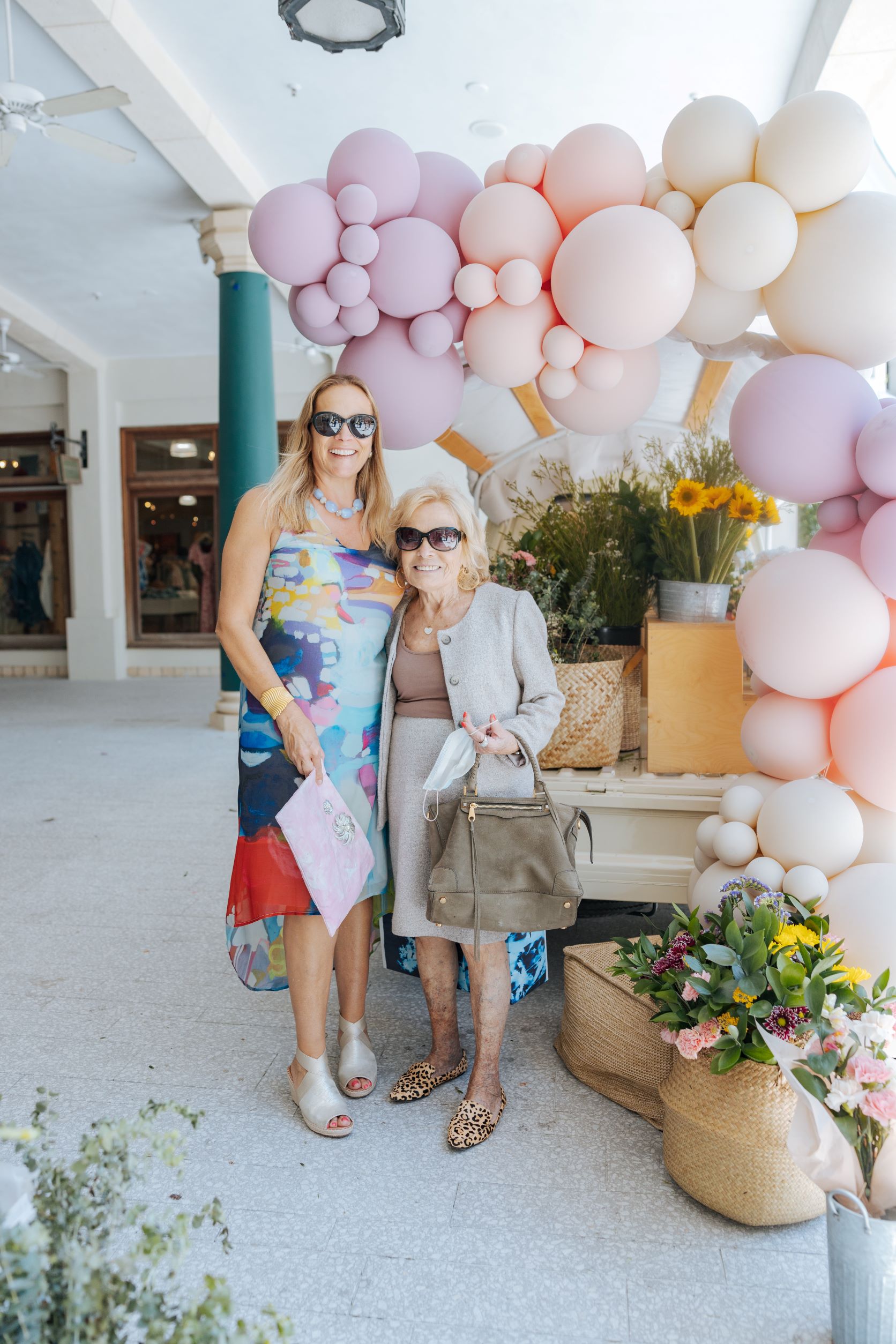 Mother and daughter posing in front of balloon arch 