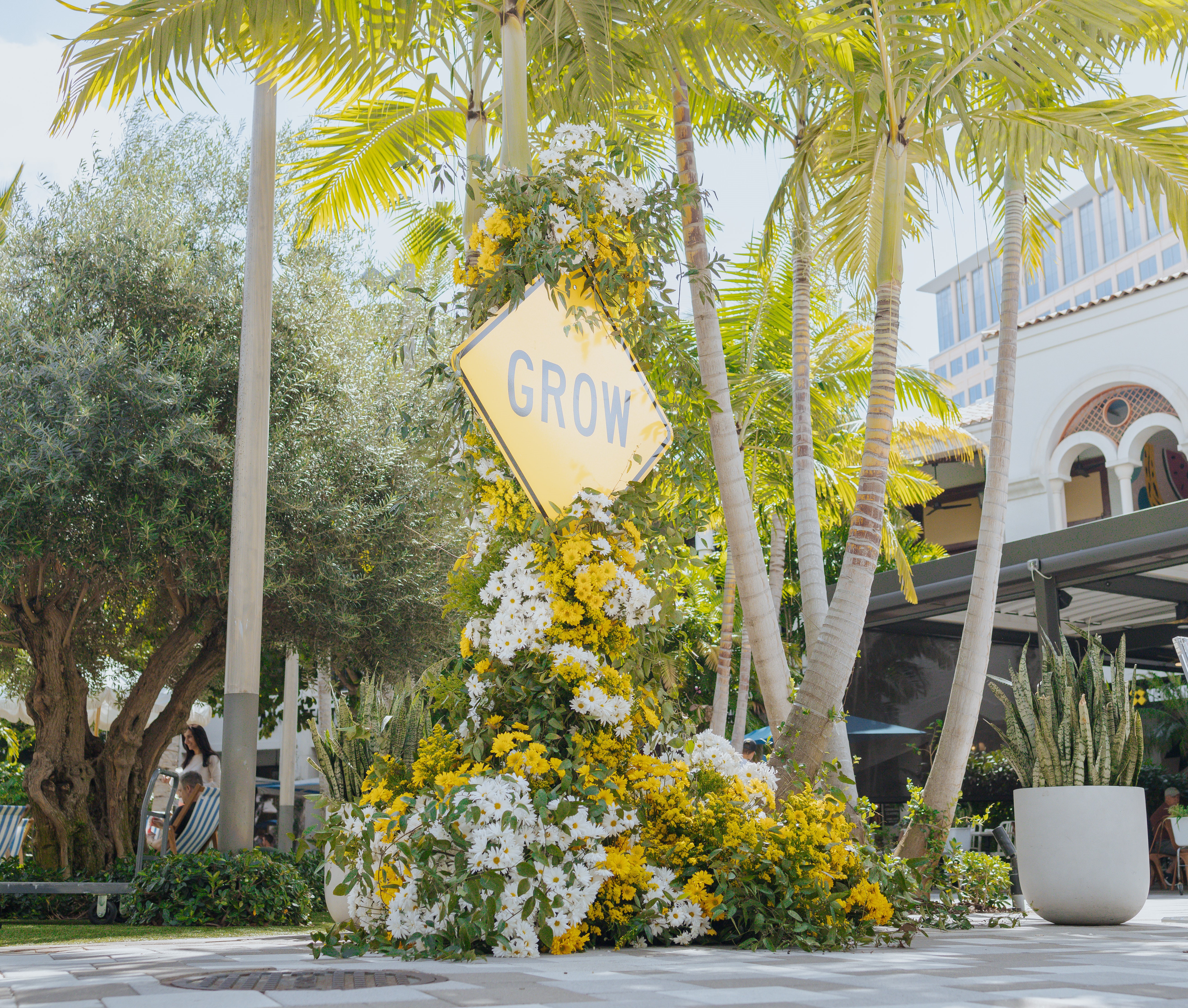 Street sign with flowers around it 