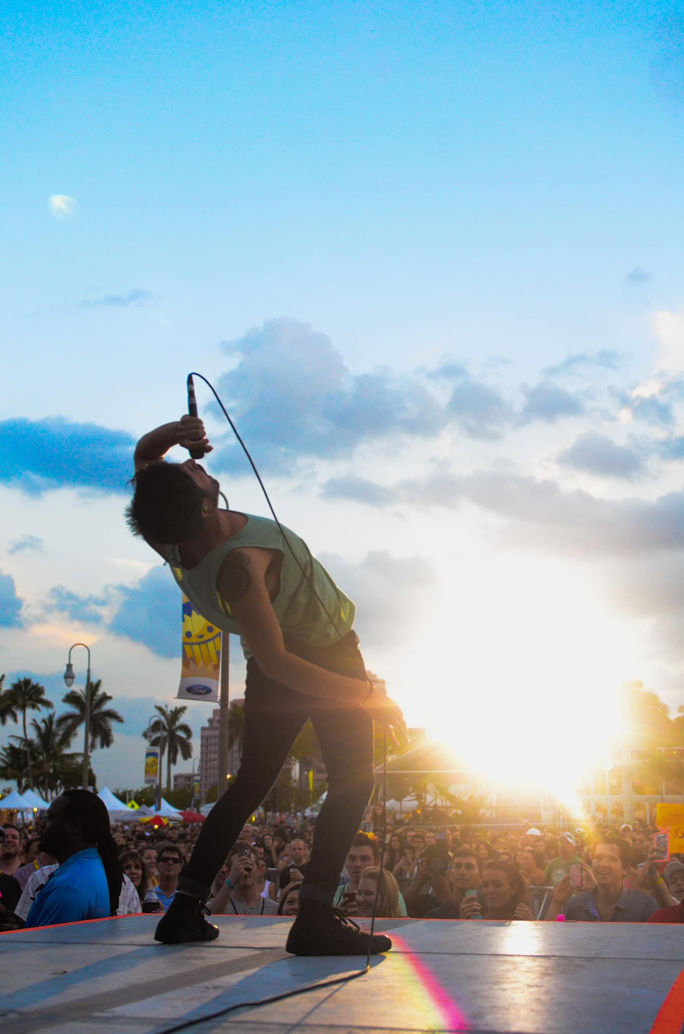 man signing with a microphone to a crowd