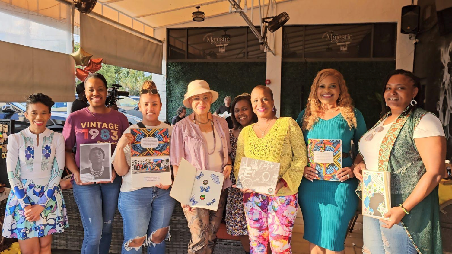 seven women standing together and holding their projects