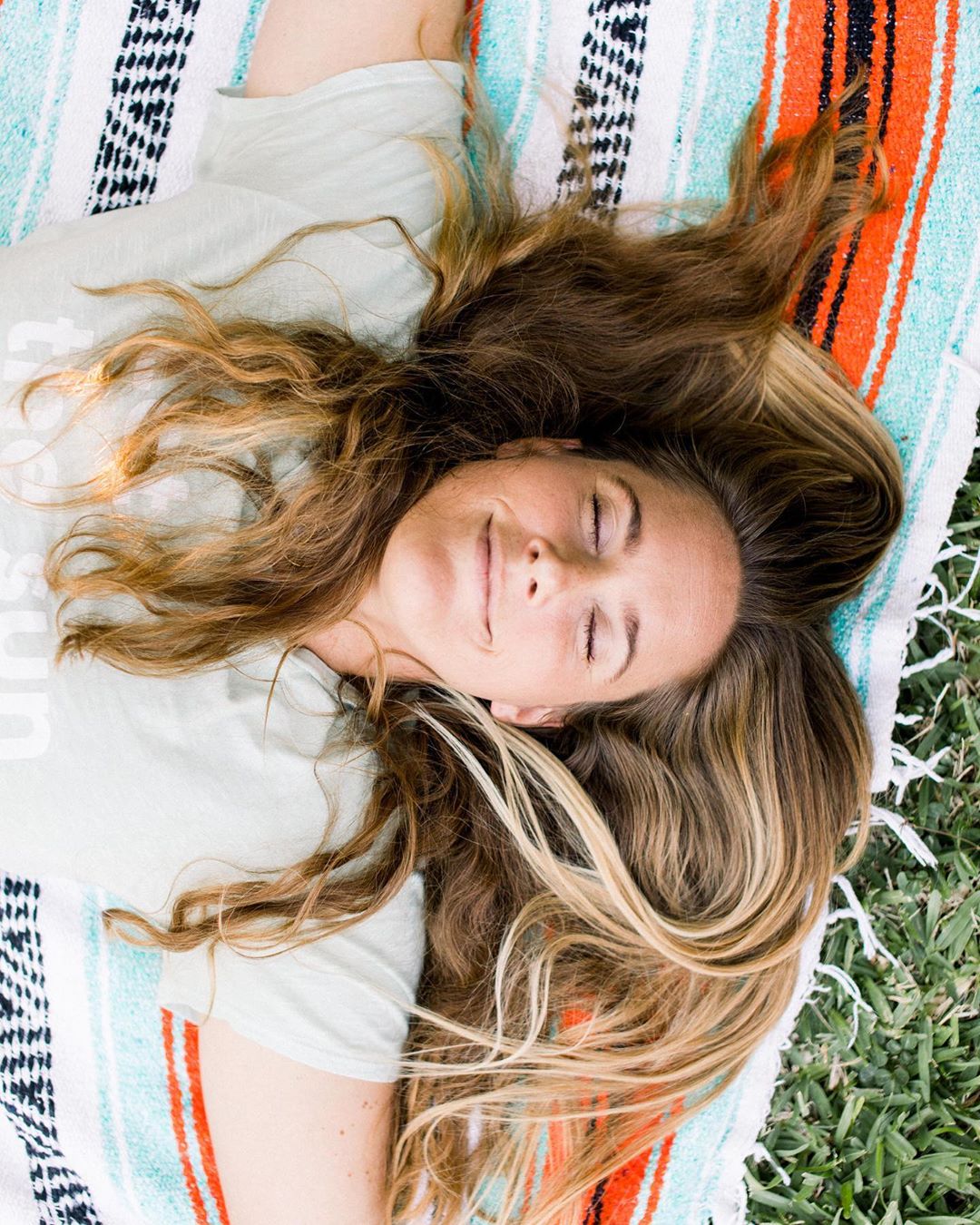 Life coach Linda Andrews meditating on a lawn 