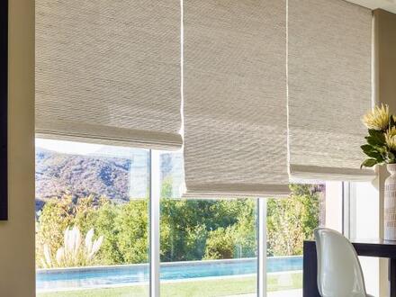 half drawn shades on a three-paned window