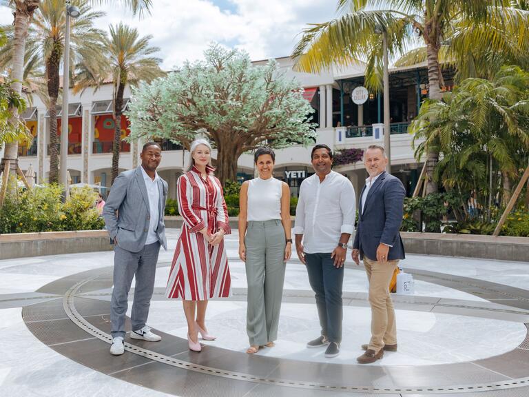 Three men and two women who work in the arts posing together outside