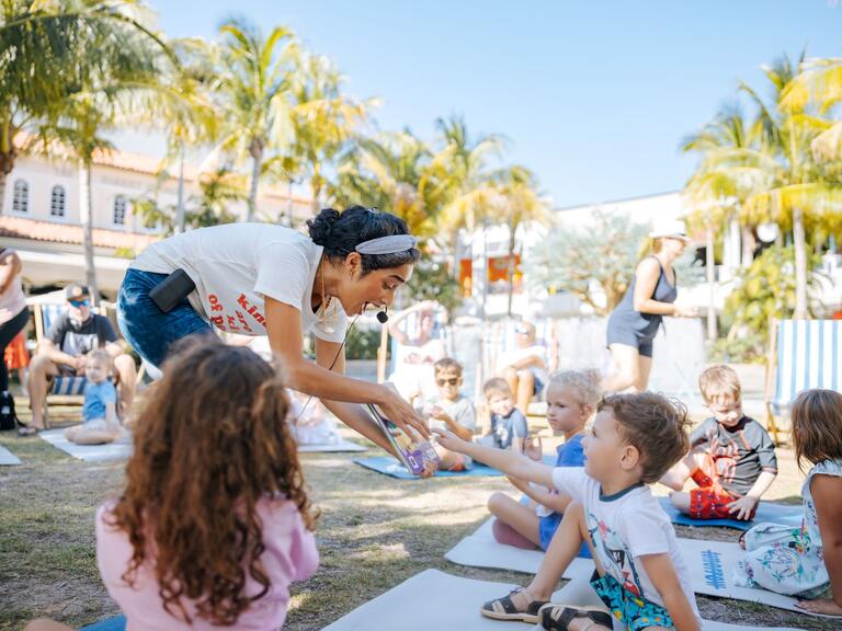 woman reading stories to young kids outside