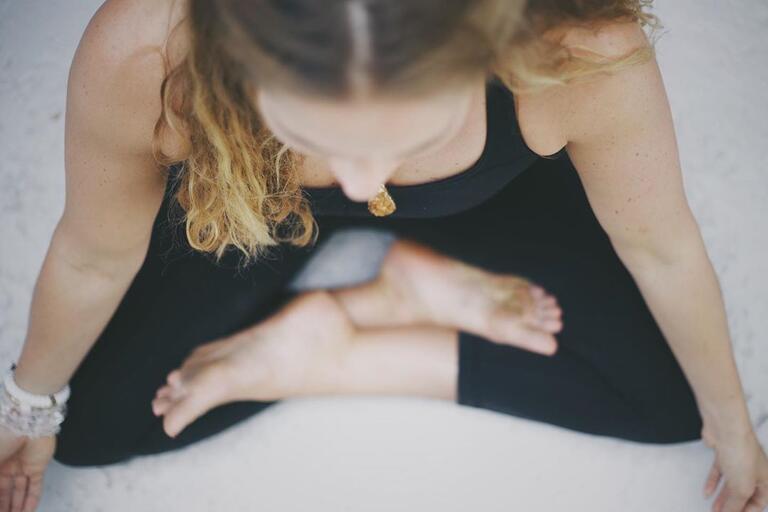 Woman sitting cross legged meditating 