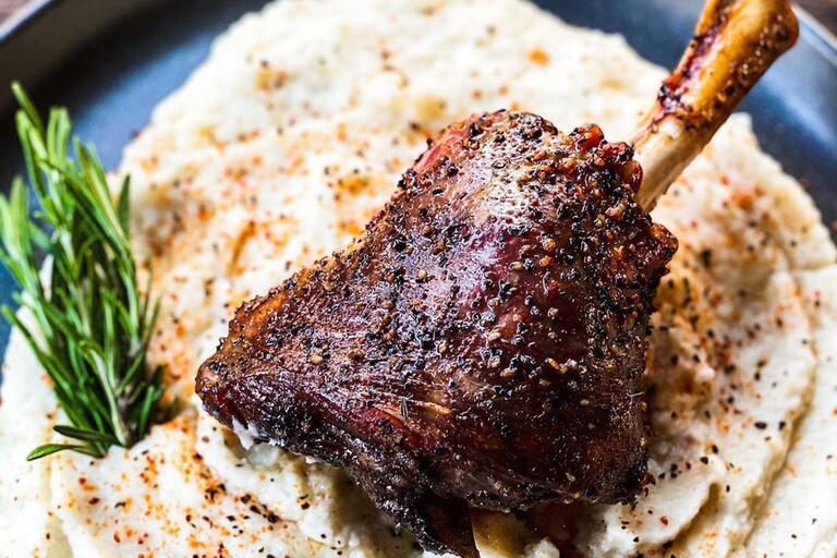 Smoked lamb shank over a bed of potatoes 