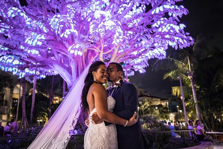 Bride and groom kissing under the wishing tree