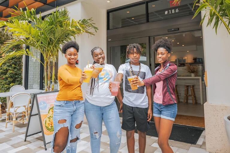 Group of four teens posing in front of Pura Vida cafe 