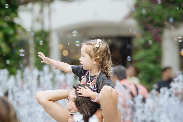 Mom and child in water fountain 