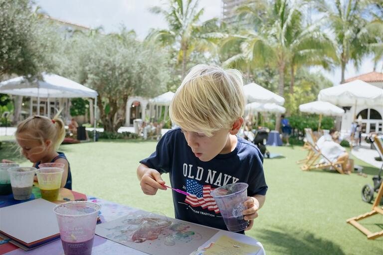 Kid doing a bubble activity on the lawn