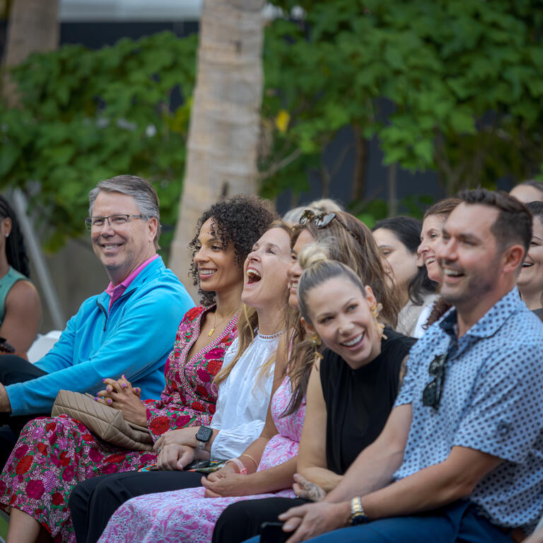 People laughing while listening to a speaker