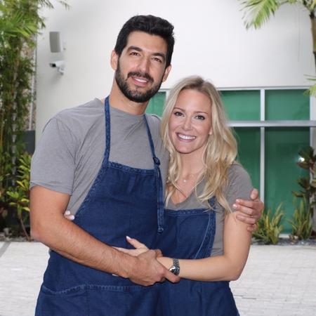 a man and woman wearing blue aprons with arms around each other