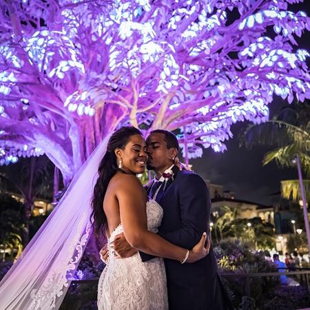 Bride and groom kissing under the wishing tree